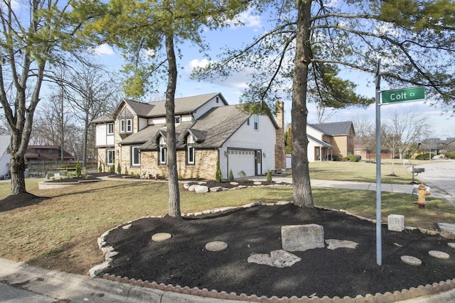 view of front of property with a garage, stone siding, driveway, and a front lawn