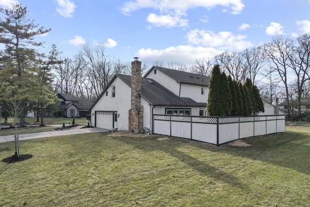 view of property exterior with driveway, fence, a lawn, and stucco siding