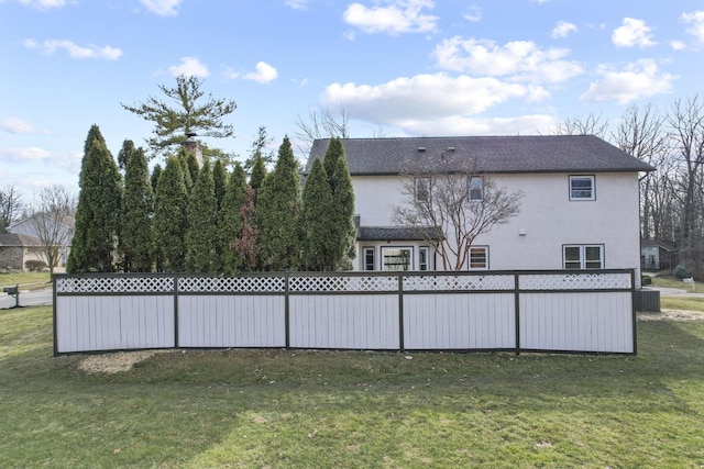 rear view of property featuring a yard and stucco siding