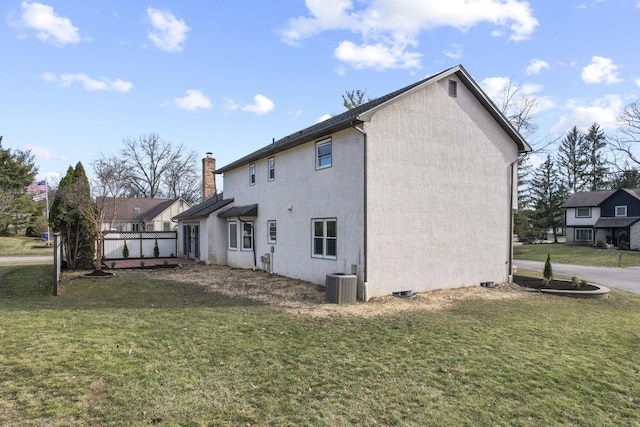 view of side of property with a lawn, a chimney, cooling unit, and stucco siding