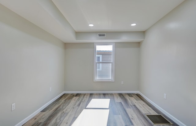 unfurnished room with visible vents, baseboards, and wood finished floors