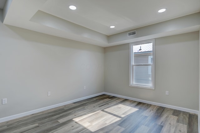 unfurnished room with baseboards, visible vents, wood finished floors, and recessed lighting