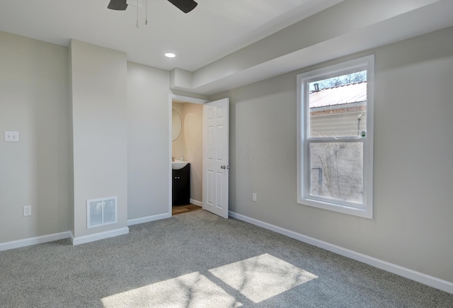 unfurnished bedroom with carpet, visible vents, and baseboards