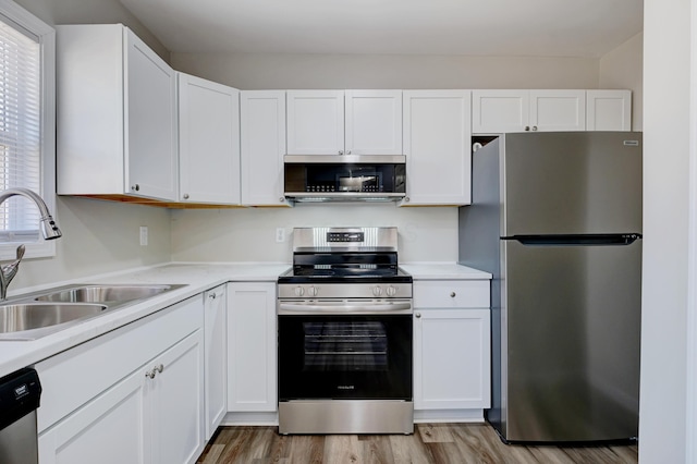 kitchen with light countertops, appliances with stainless steel finishes, and a sink