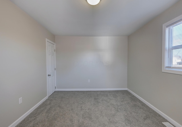 spare room featuring baseboards, visible vents, and carpet flooring