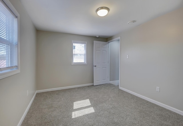 carpeted empty room with baseboards