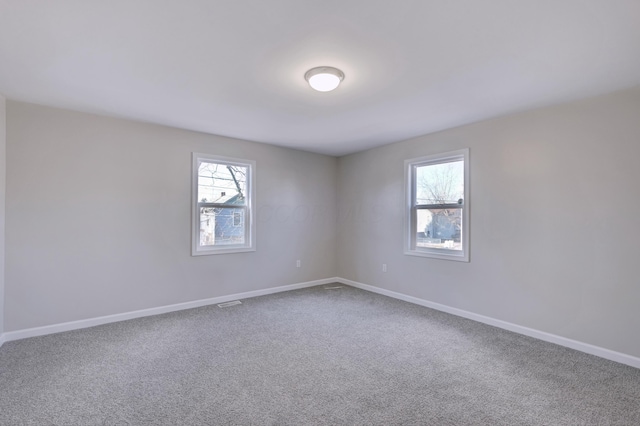 carpeted spare room with baseboards