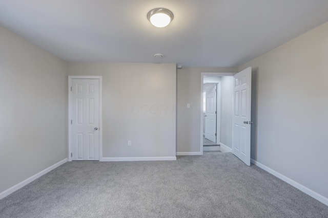 unfurnished bedroom featuring carpet and baseboards