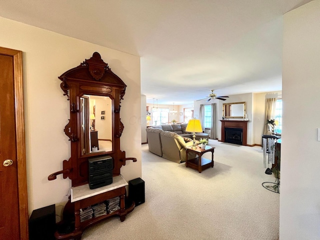 carpeted living room with a fireplace and ceiling fan