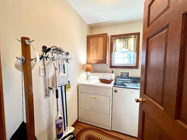 washroom with wood finished floors, cabinet space, and independent washer and dryer