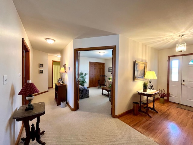 foyer entrance with light wood-style flooring and baseboards