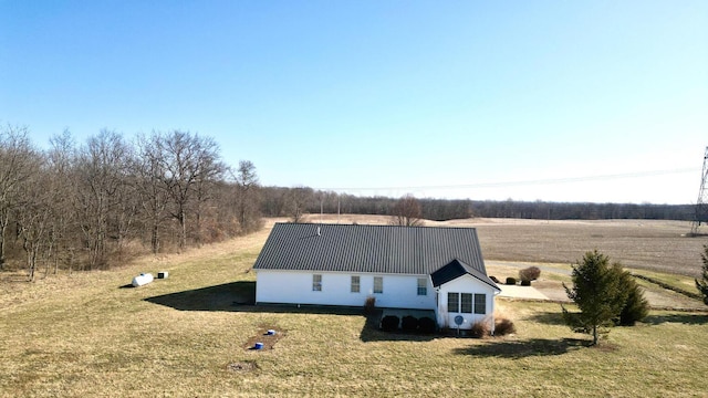 exterior space featuring metal roof and a lawn