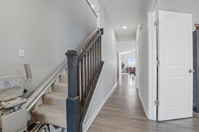 stairs with recessed lighting, wood finished floors, and baseboards