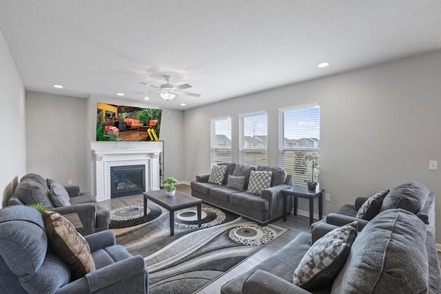 living area featuring baseboards, a tiled fireplace, wood finished floors, and recessed lighting