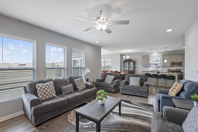 living area featuring ceiling fan, baseboards, wood finished floors, and recessed lighting