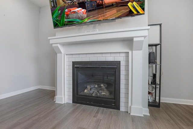 interior details with a fireplace, baseboards, and wood finished floors