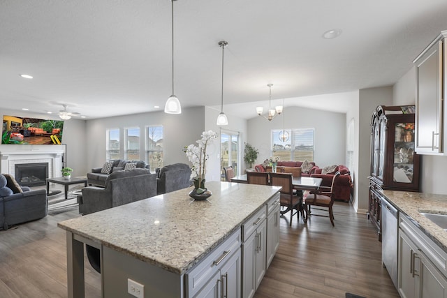 kitchen featuring dishwasher, open floor plan, dark wood-type flooring, gray cabinetry, and a brick fireplace