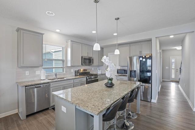 kitchen featuring tasteful backsplash, appliances with stainless steel finishes, a sink, and gray cabinetry