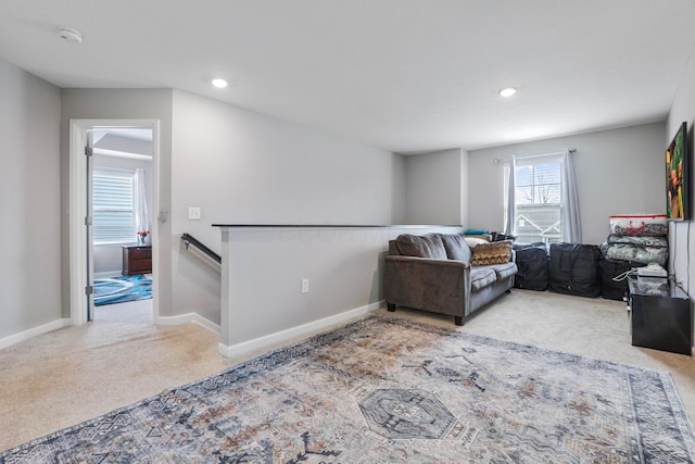 carpeted living area featuring baseboards and recessed lighting