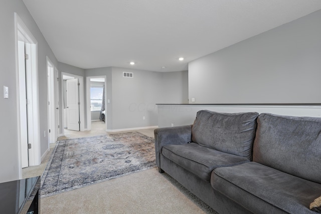 living area with recessed lighting, light carpet, visible vents, and baseboards