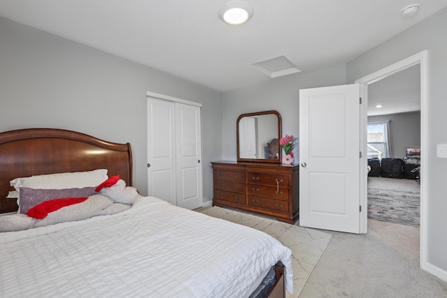 bedroom featuring light carpet, attic access, baseboards, and a closet