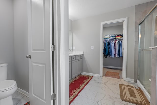 bathroom featuring baseboards, toilet, marble finish floor, vanity, and a shower stall