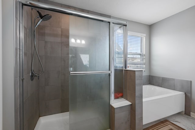 bathroom featuring a garden tub and a shower stall