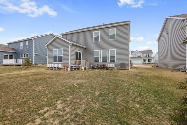 rear view of house featuring a lawn and central AC unit