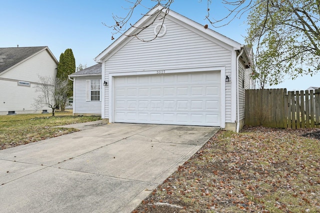 garage with fence and concrete driveway