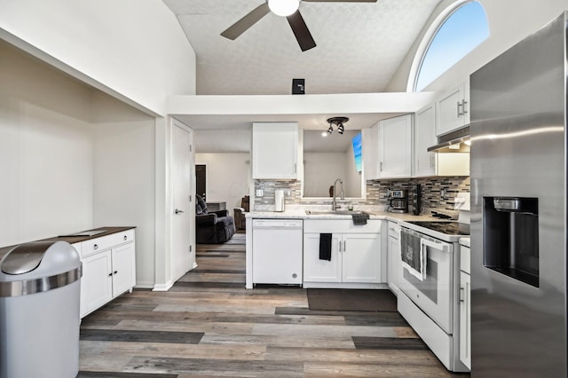 kitchen with white appliances, white cabinets, and a sink