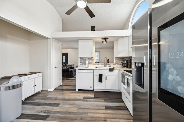 kitchen with white appliances, white cabinets, and wood finished floors