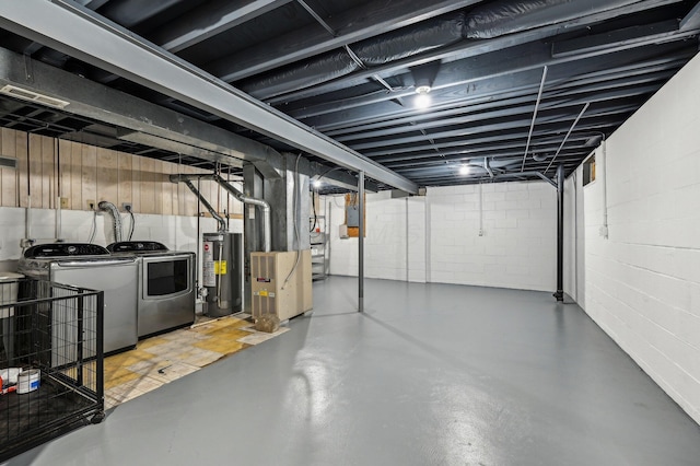 unfinished below grade area with water heater, washer and clothes dryer, concrete block wall, and heating unit