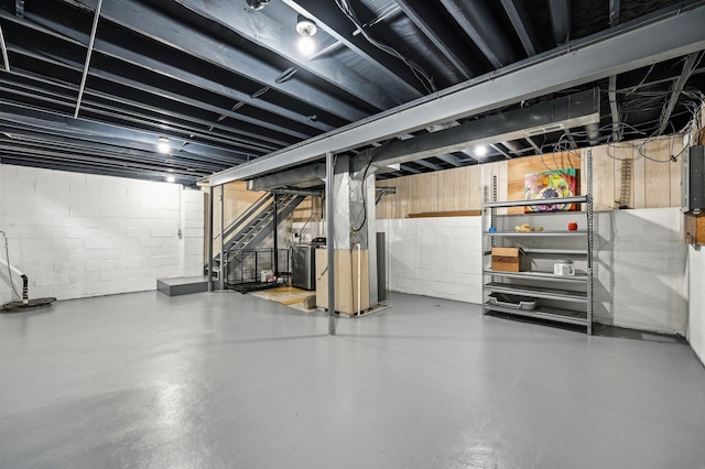 unfinished basement featuring washer / clothes dryer and stairs