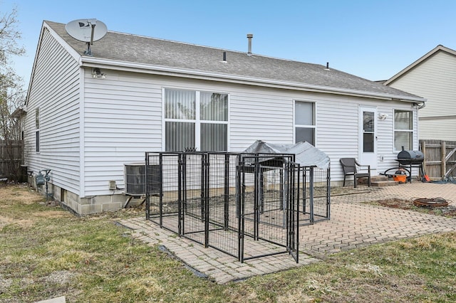 back of house featuring a yard, roof with shingles, fence, and a patio