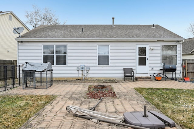 back of property featuring entry steps, a patio area, fence, and roof with shingles