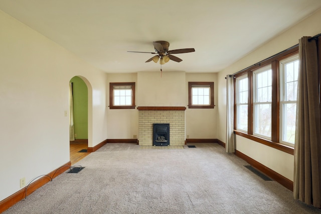 unfurnished living room with a healthy amount of sunlight, visible vents, and baseboards