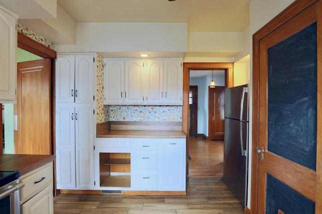 kitchen with white cabinets, stainless steel appliances, and wood finished floors