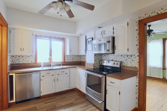 kitchen featuring white cabinets, stainless steel appliances, and a sink