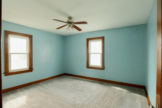 empty room featuring a ceiling fan, carpet, and baseboards