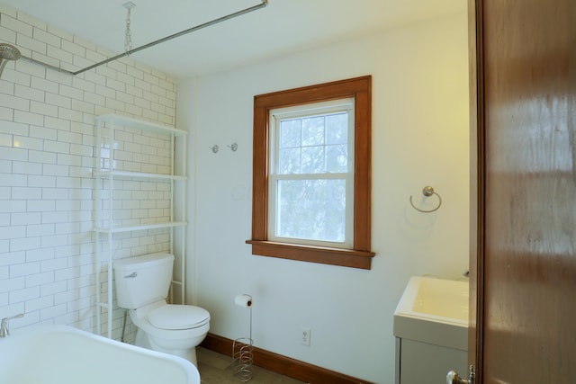 full bathroom featuring toilet, baseboards, walk in shower, and vanity