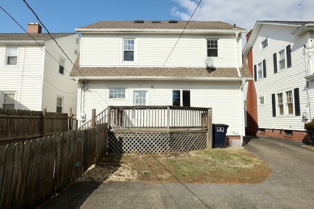 back of house with a deck, a shingled roof, fence, and aphalt driveway