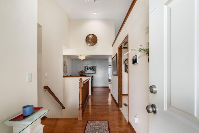 corridor featuring wood finished floors and an upstairs landing