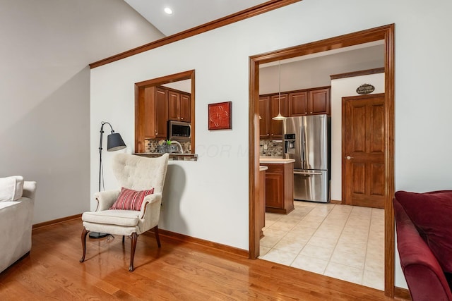 living area with light wood-type flooring and baseboards