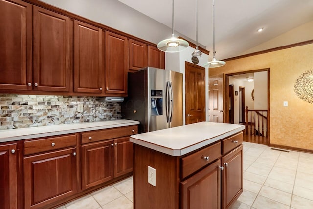 kitchen with stainless steel fridge, tasteful backsplash, lofted ceiling, a center island, and light countertops