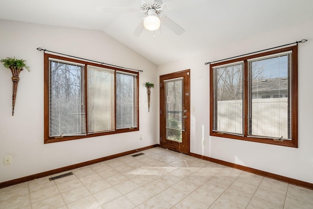 spare room featuring lofted ceiling, visible vents, and baseboards