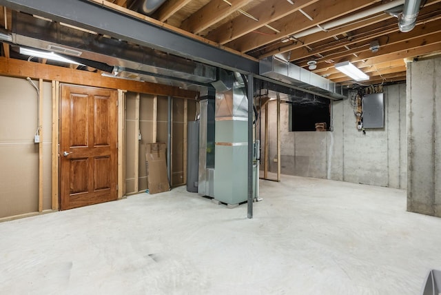 unfinished basement with heating unit, electric panel, and gas water heater