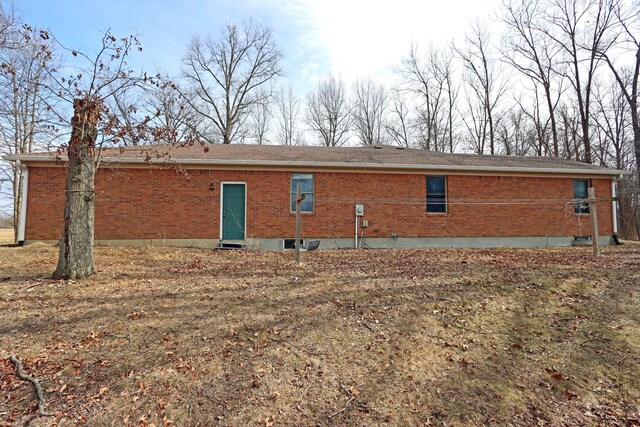 back of property with entry steps and brick siding