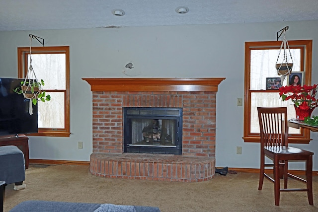 carpeted living area with a textured ceiling, a brick fireplace, and baseboards