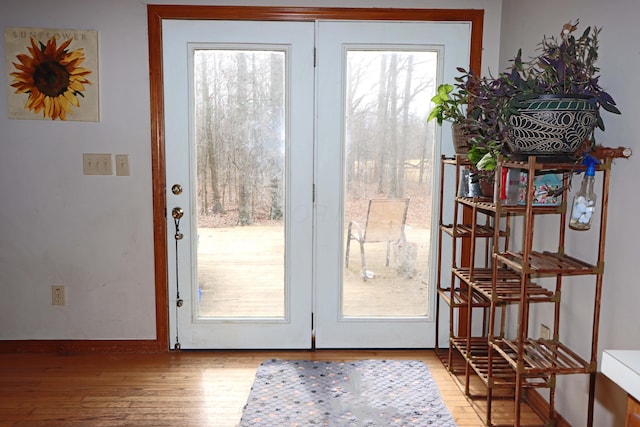 doorway with light wood-style flooring and baseboards