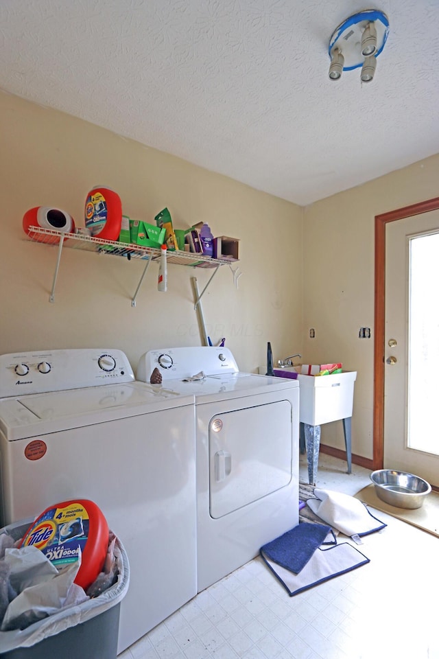 washroom with laundry area, a textured ceiling, light floors, and washer and dryer